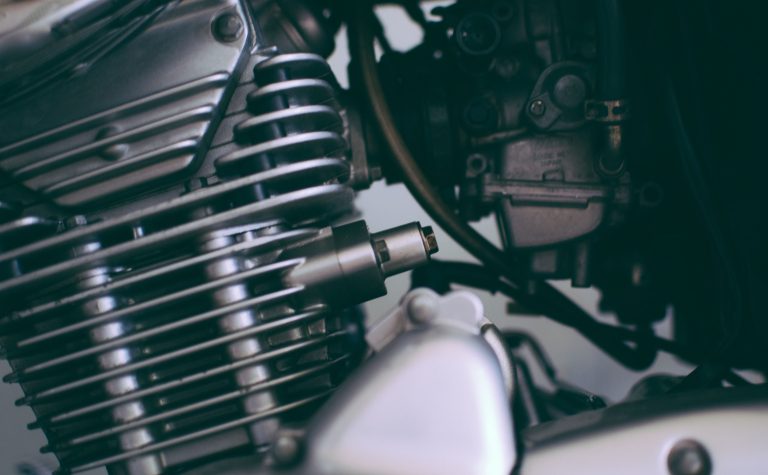 Gros plan détaillé d'un moteur de moto brillant montrant les composants métalliques.