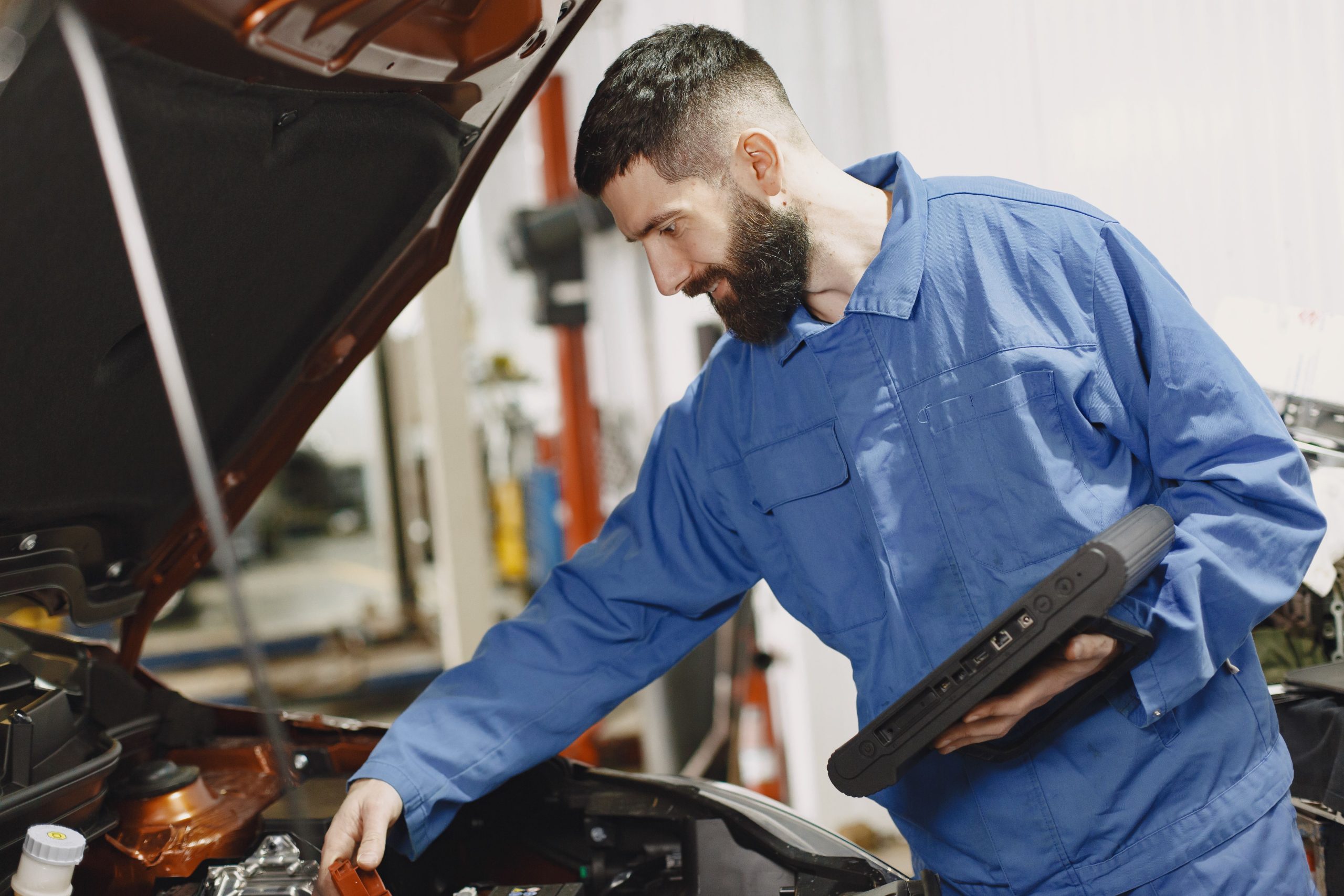 Technicien inspectant le moteur en garage
