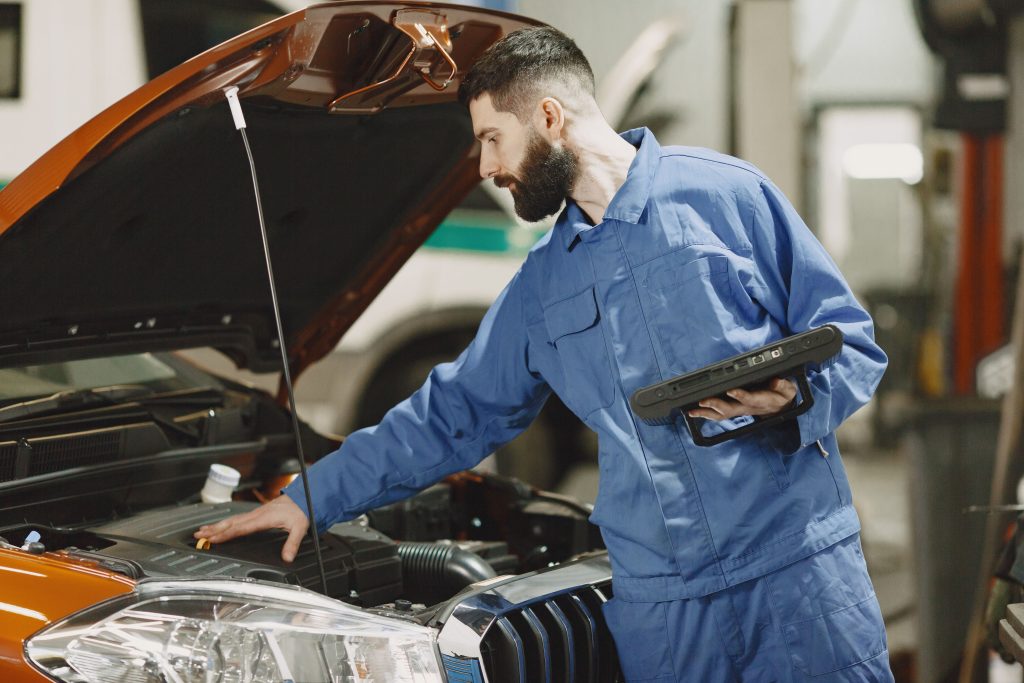 Mécanicien examinant moteur Peugeot 208