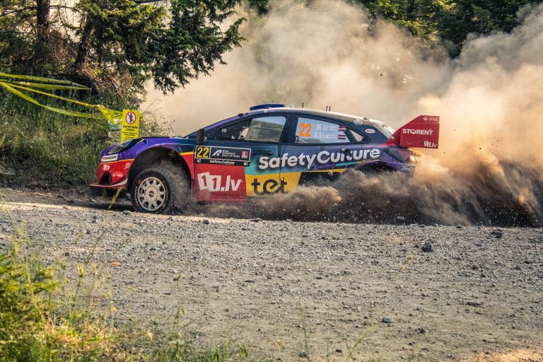 Voiture de rallye dans la poussière sur route gravillonnée