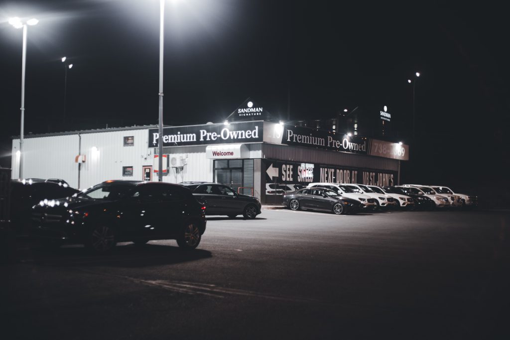 Concessionnaire automobile illuminé avec véhicules d'occasion