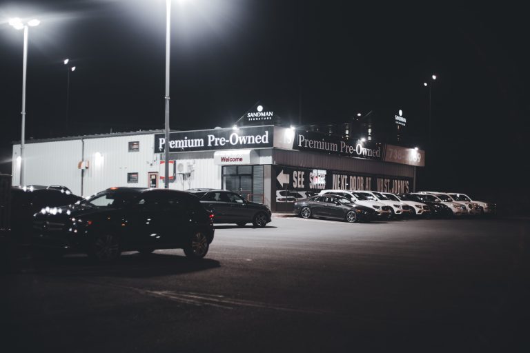 Concessionnaire automobile illuminé avec véhicules d'occasion