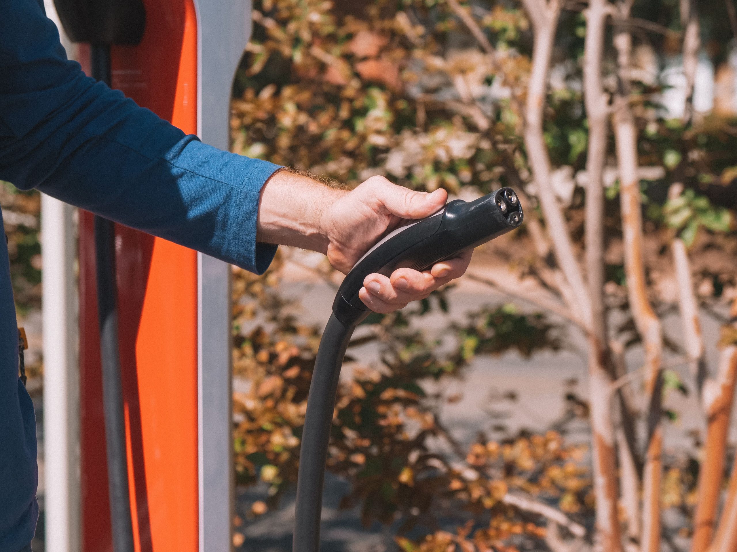Main tenant connecteur recharge véhicule hybride