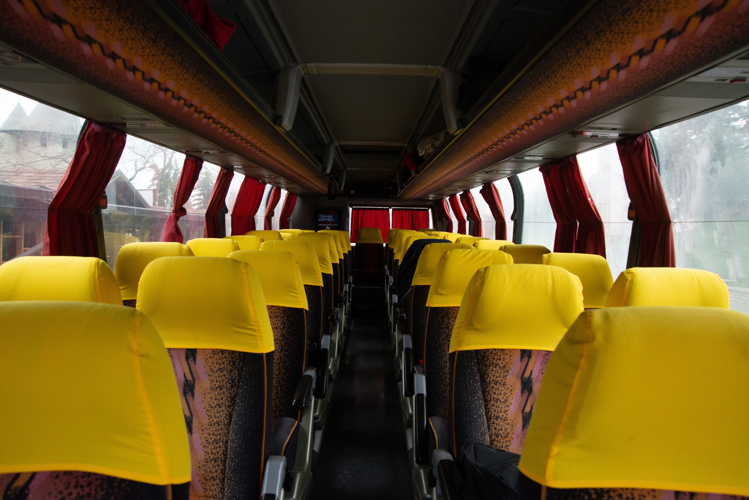 Bus avec sièges jaunes et rideaux rouges