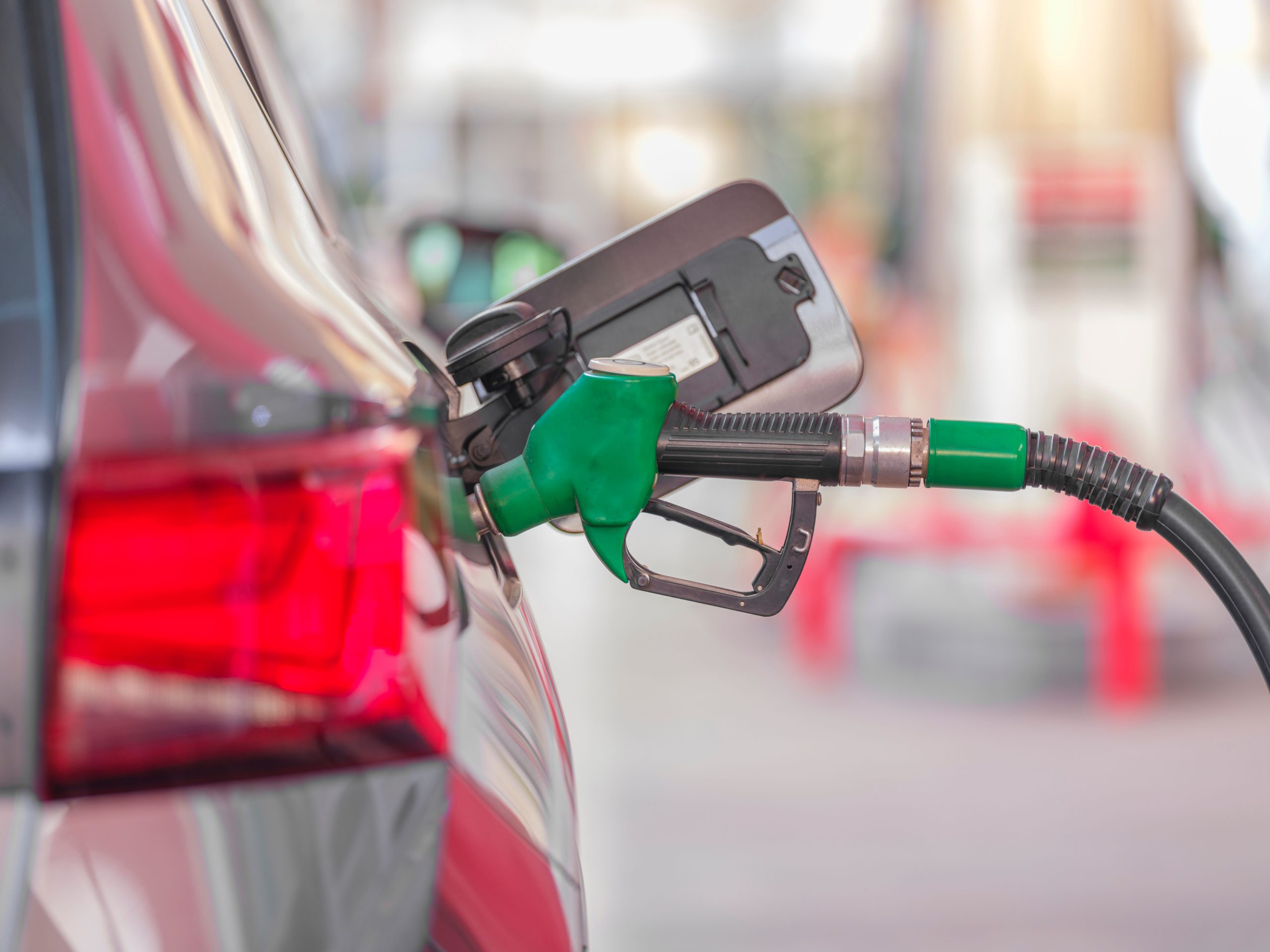 Pistolet de pompe essence inséré dans réservoir voiture station