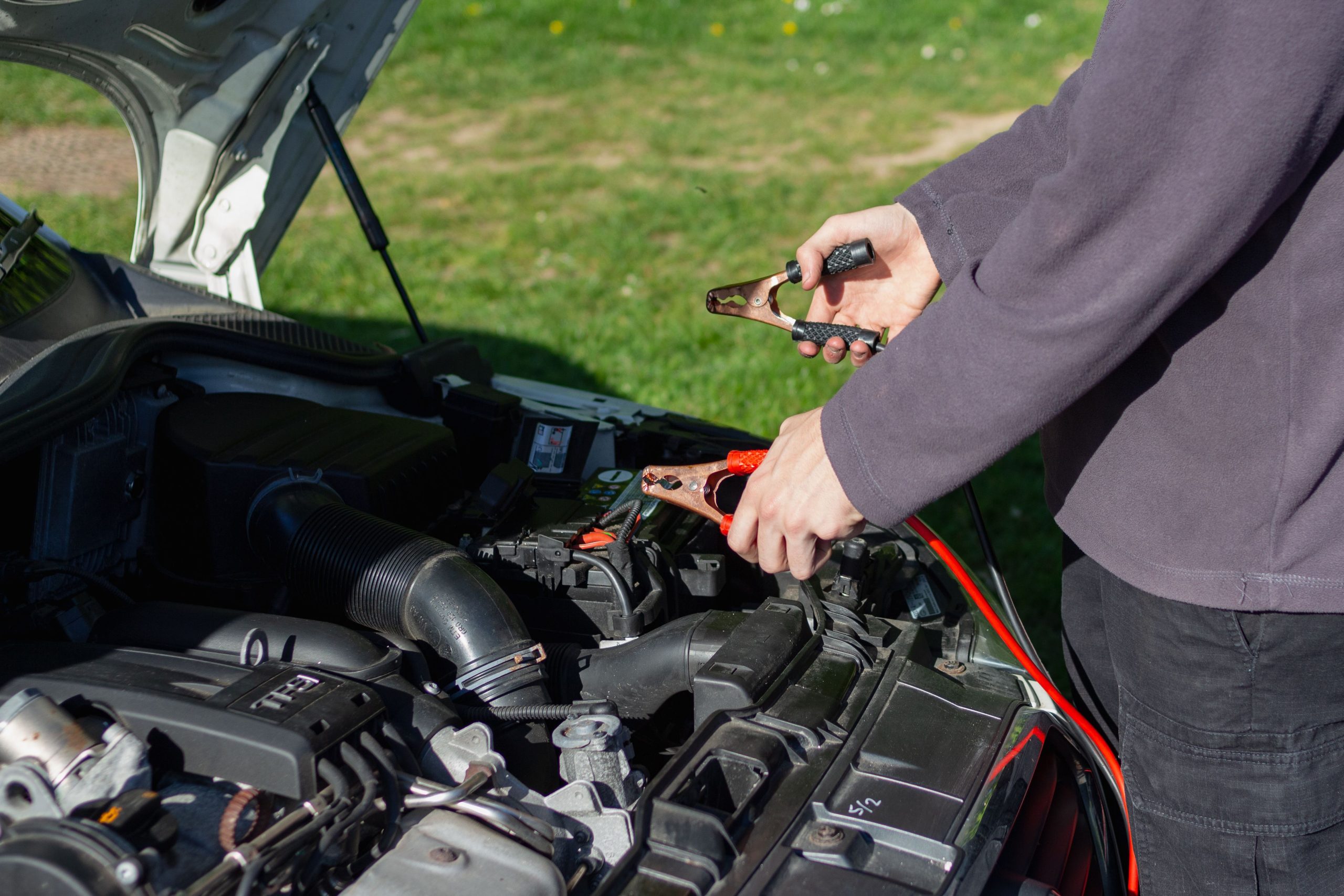 Mécanicien recharge batterie auto avec câbles