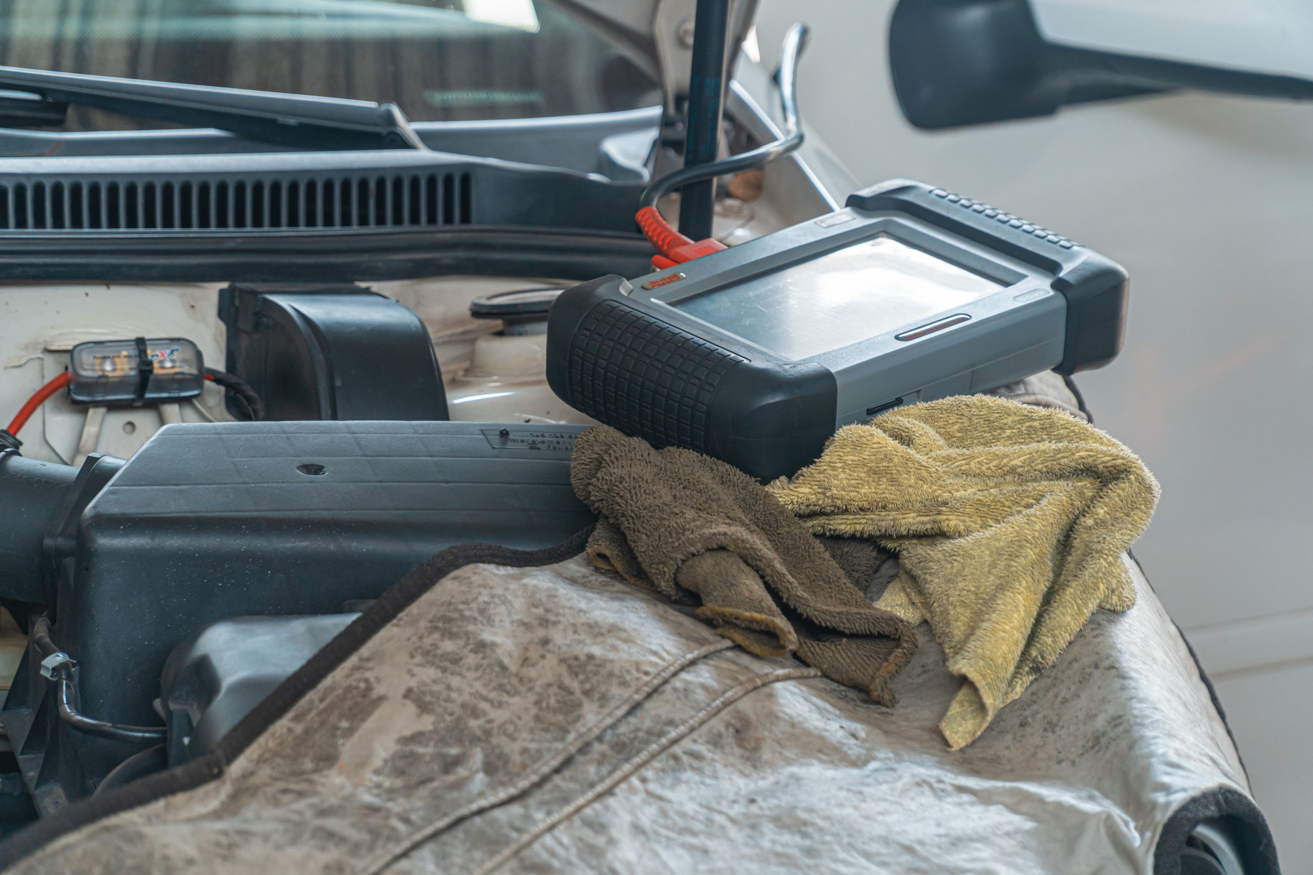 Outil diagnostic automobile sur moteur en garage