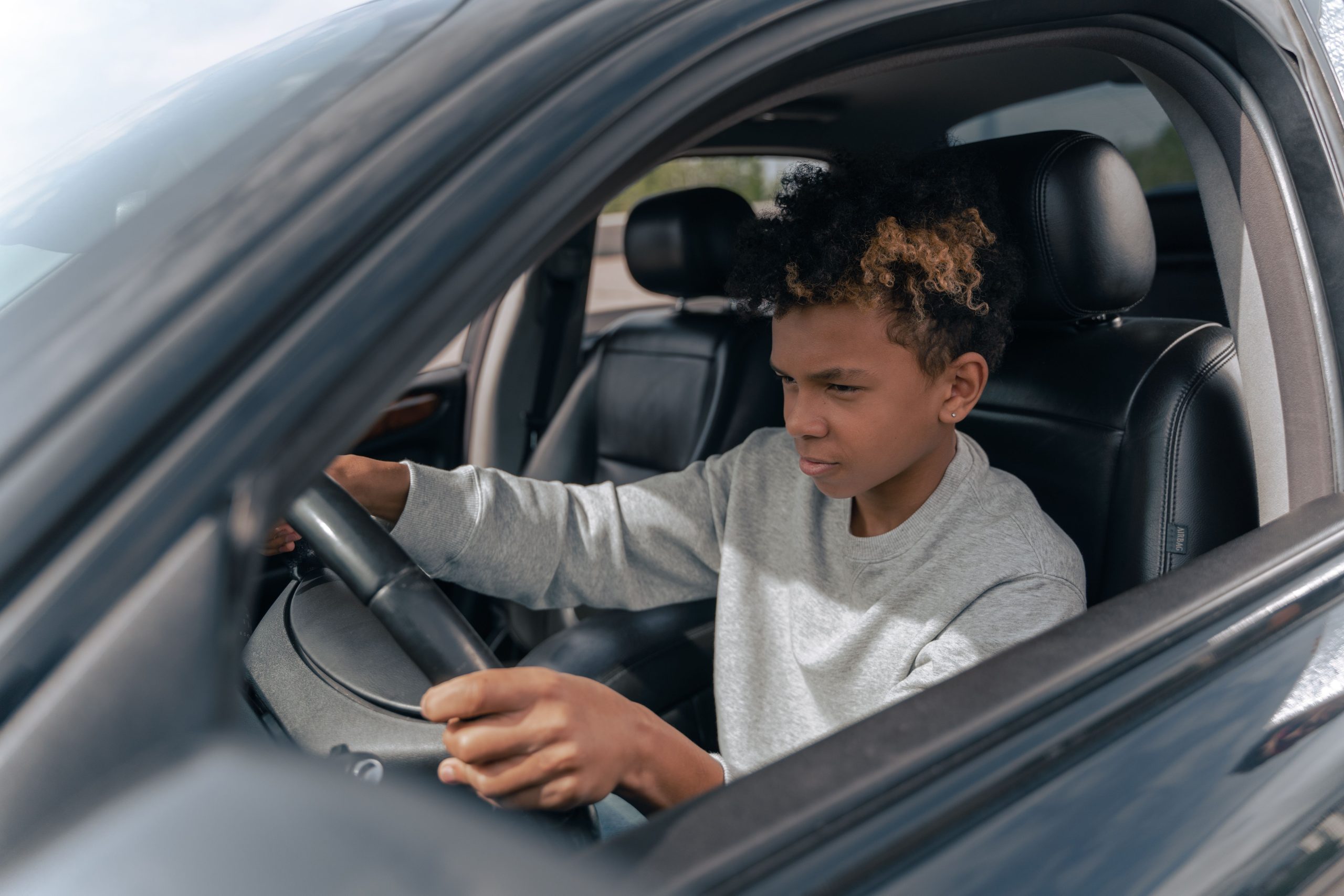 Jeune garçon concentré apprenant à conduire voiture