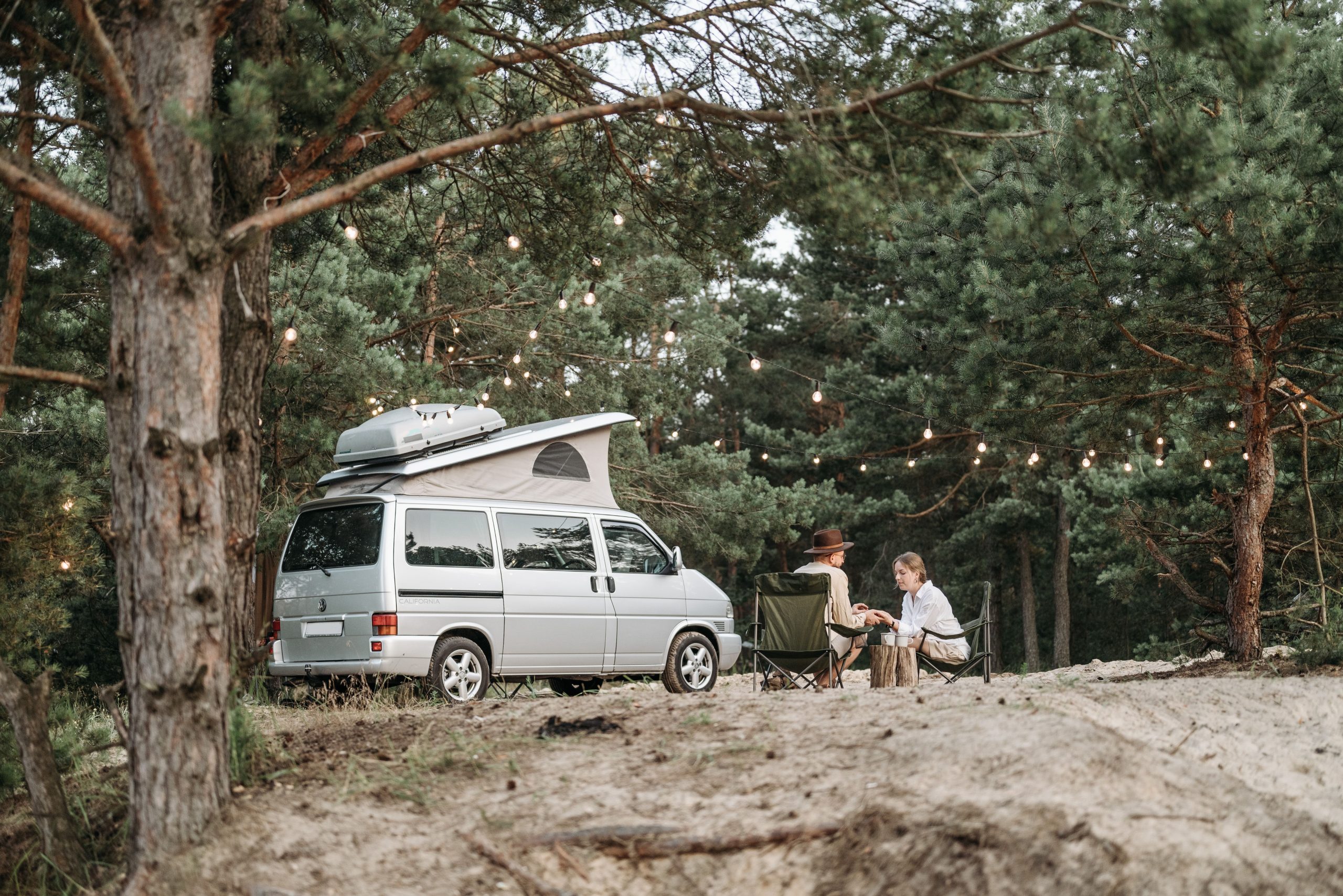 Couple détente camping-car forêt lumières guirlandes