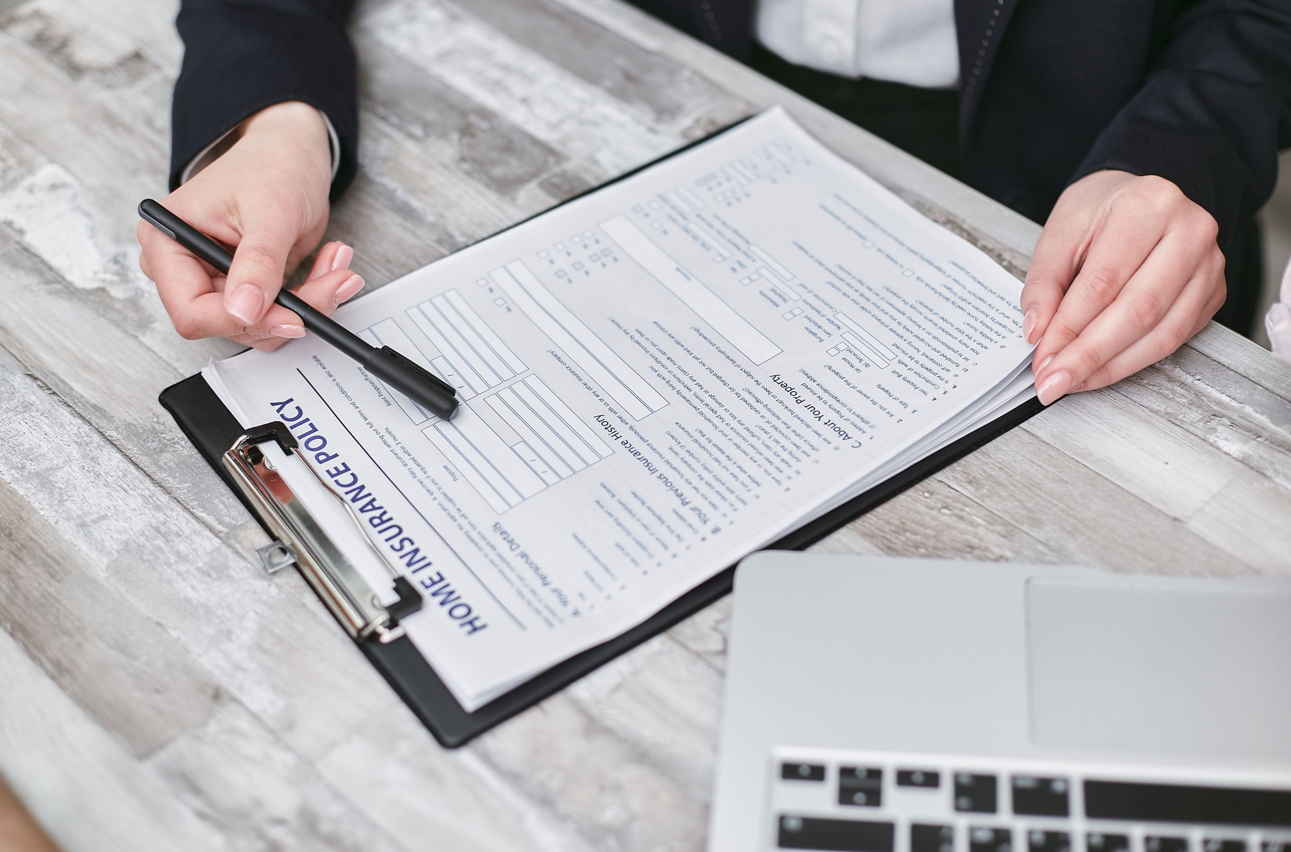 Mains examinant un contrat d'assurance habitation