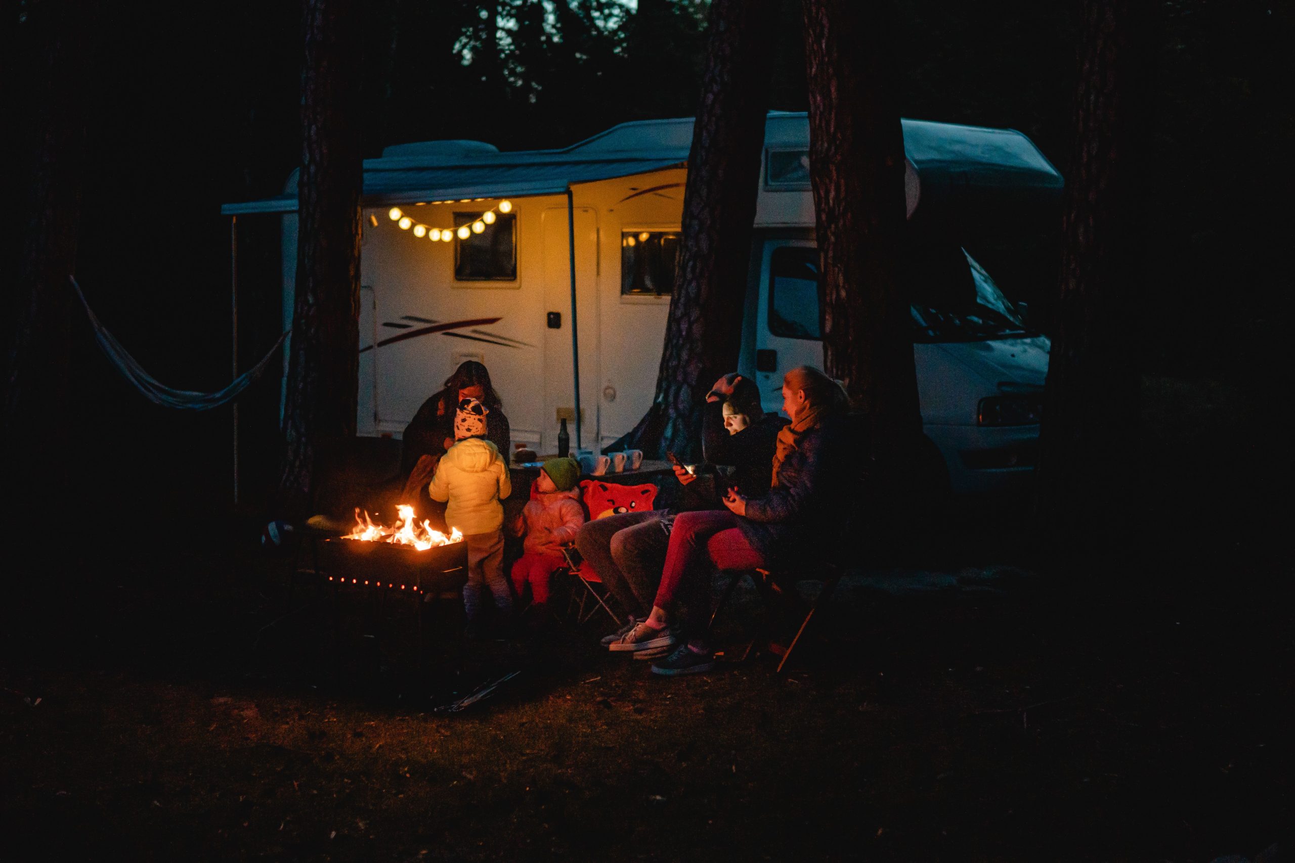Famille autour du feu de camp près du camping-car