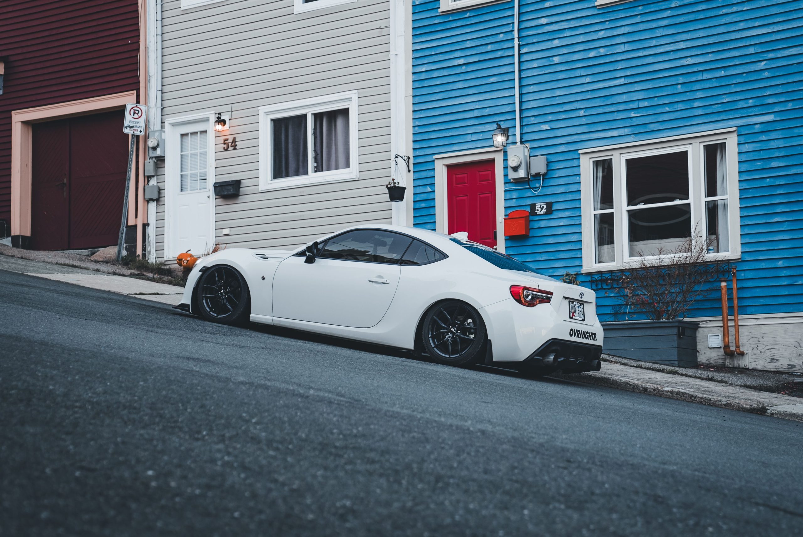Voiture sport blanche sur rue pentue urbaine