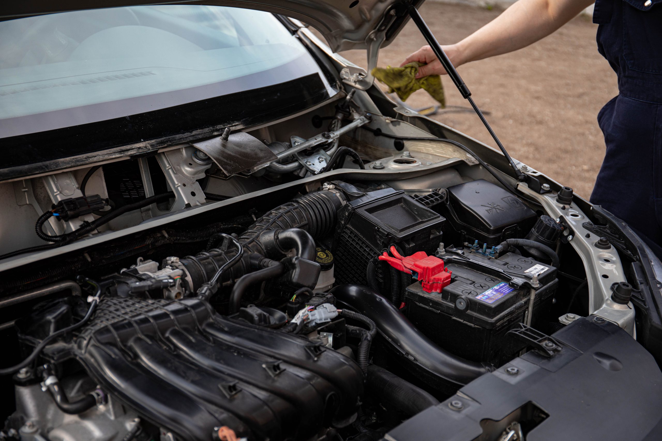 Mécanicien inspectant le compartiment moteur d'une voiture