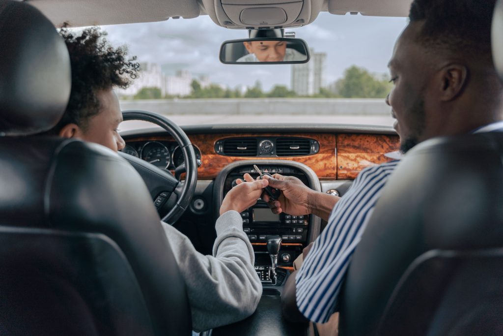 Père et fils adolescent apprenant à conduire en voiture