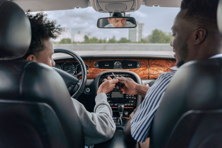 Père et fils adolescent apprenant à conduire en voiture