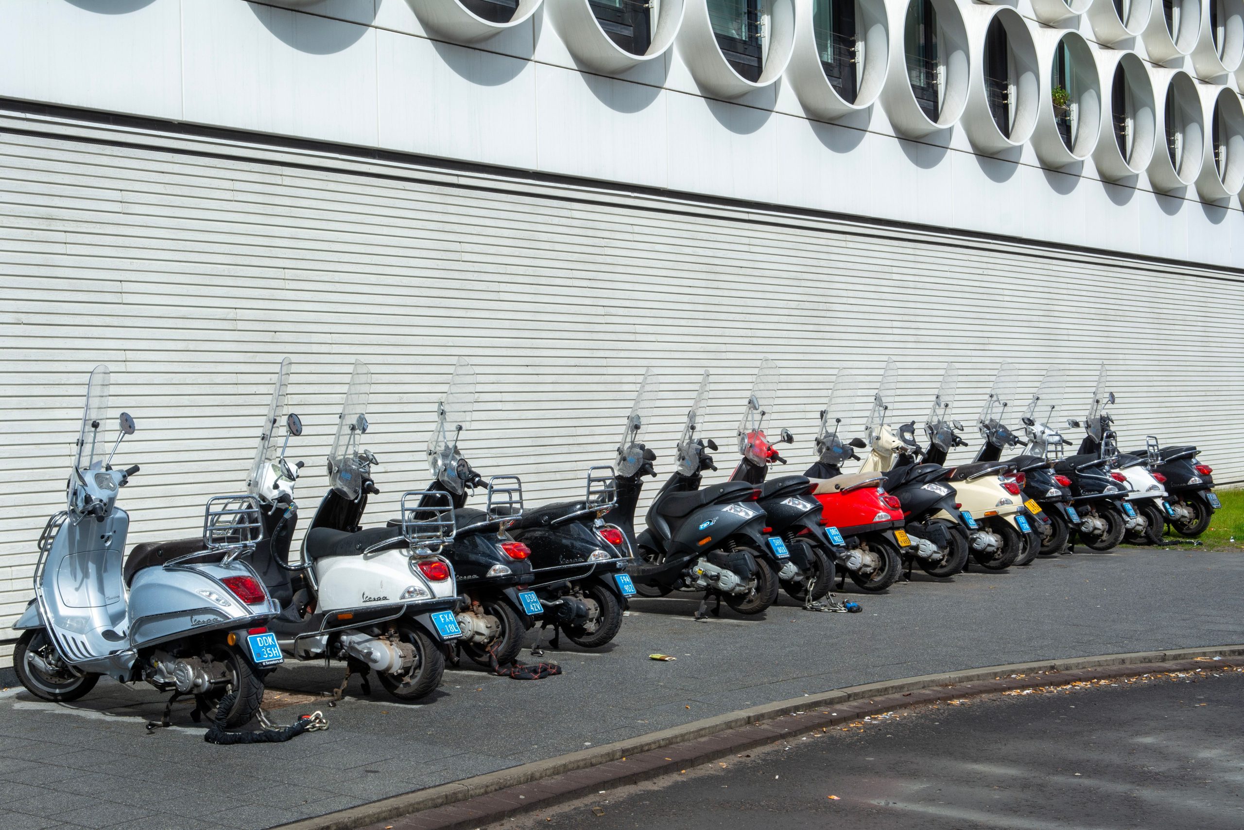 File de scooters garés en environnement urbain