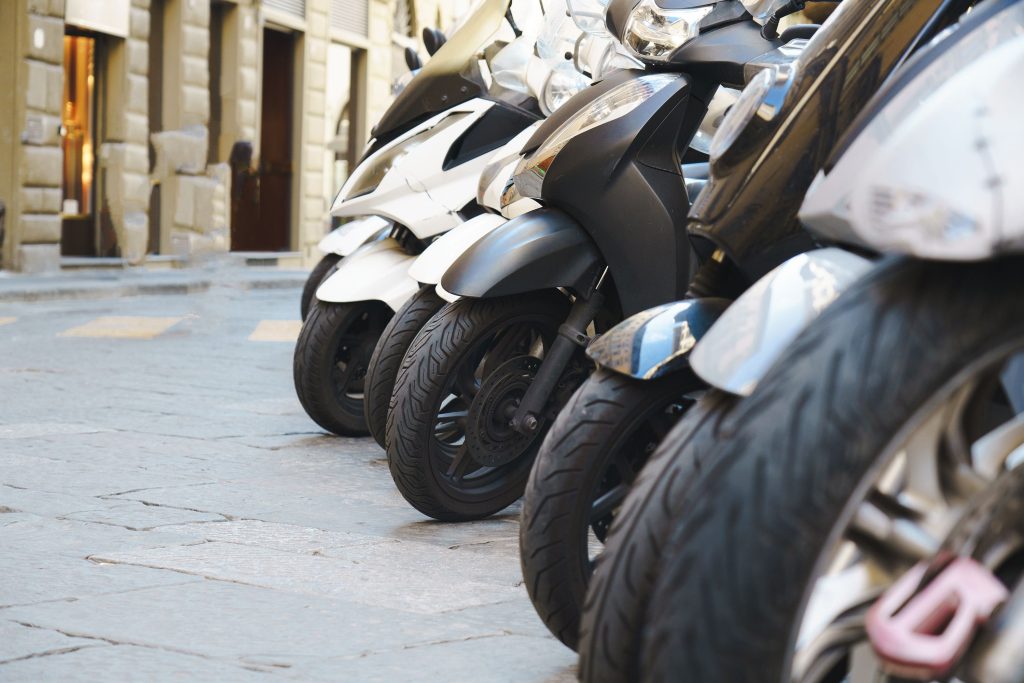 Scooters garés alignés dans une rue urbaine